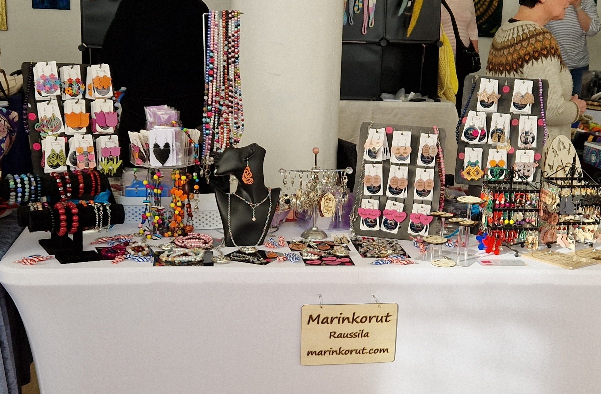 Messupöytä täynnä käsintehtyjä korvakoruja Marinkorut.com-verkkokaupasta